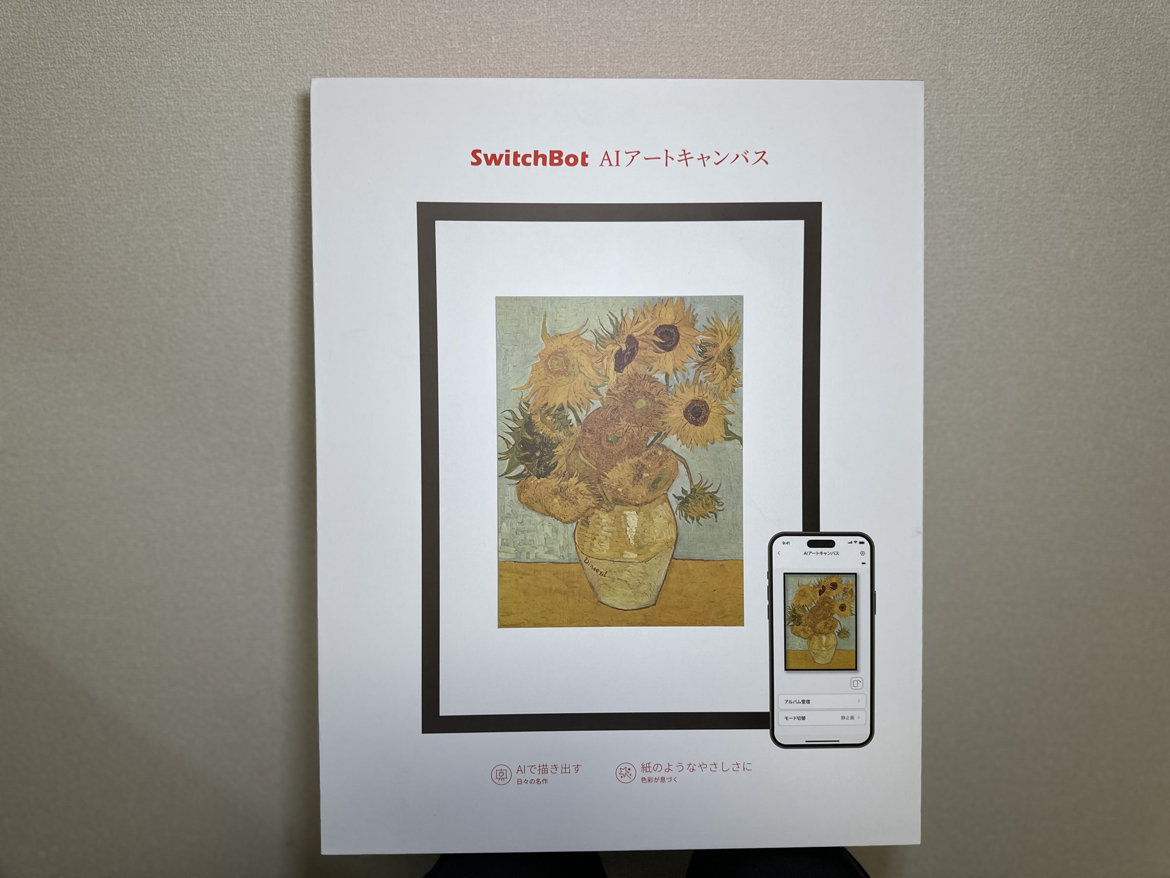 SwitchBot AIアートキャンバスの製品箱。前面にはひまわりの絵を表示したフレームとスマホアプリのイメージが載っている