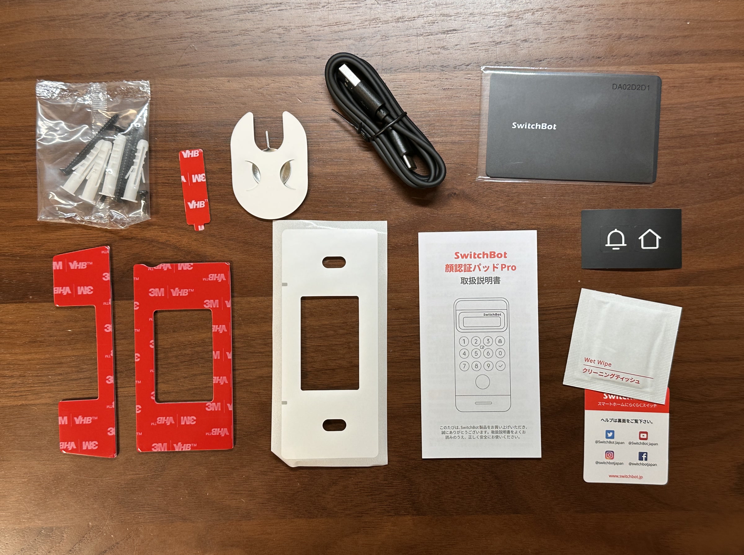 SwitchBot 顔認証パッドProの同梱物。取り付けプレート、両面テープ、ネジ類、USBケーブル、説明書、本体が含まれる