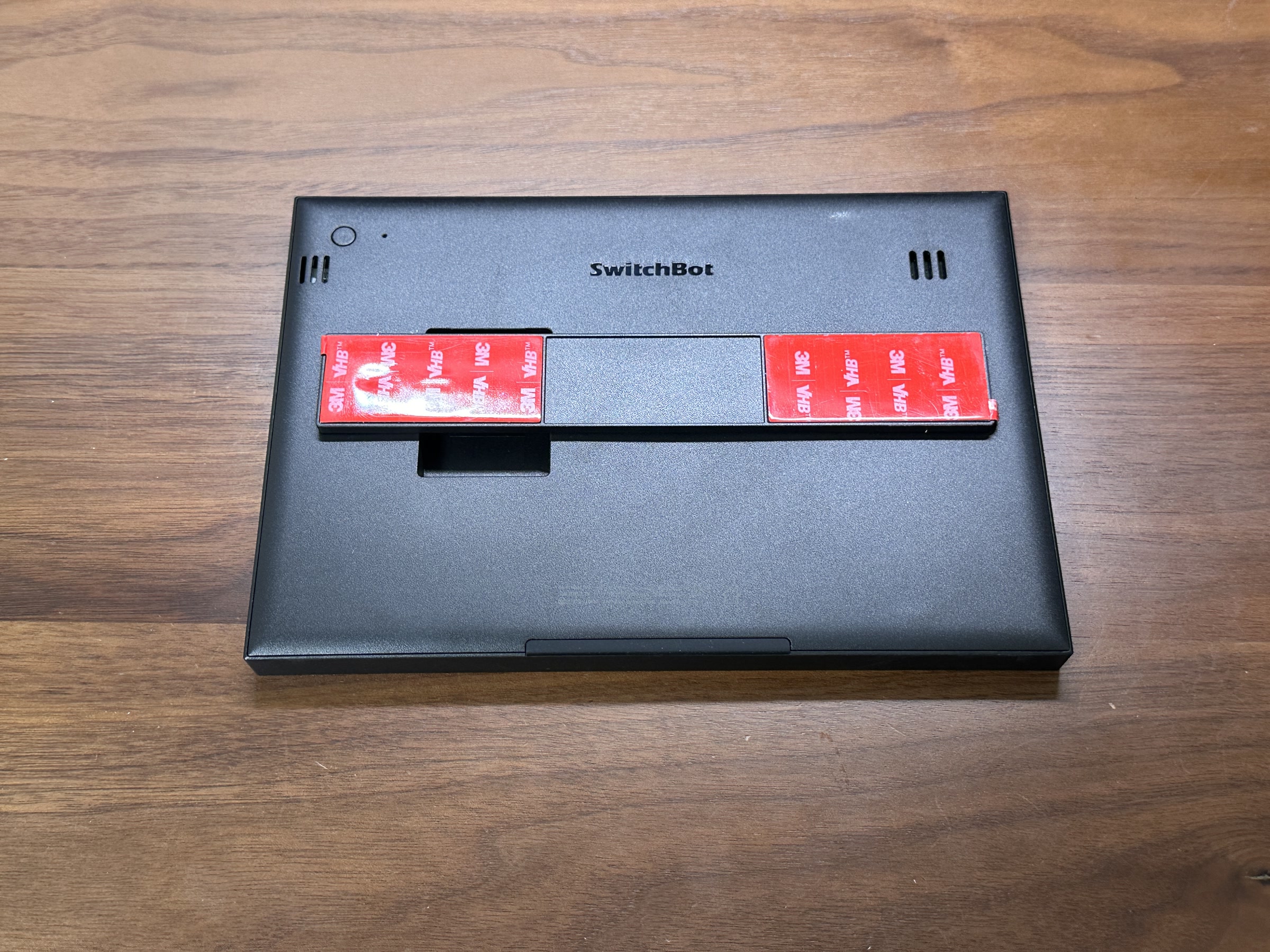 SwitchBot スマートデイリーステーション背面に貼り付け用パーツを装着した状態。壁やボード周辺に固定しやすい構造が分かる
